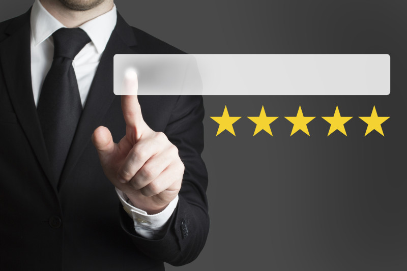 businessman in suit pushing button five rating stars