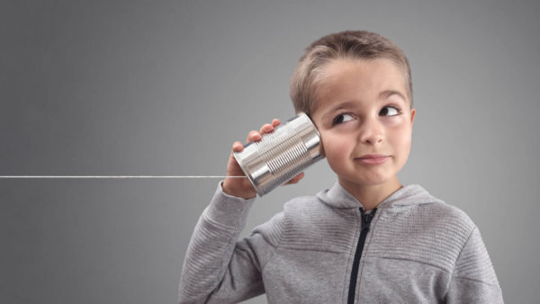 child-listening-tin-can-phone-shutterstock_744297028