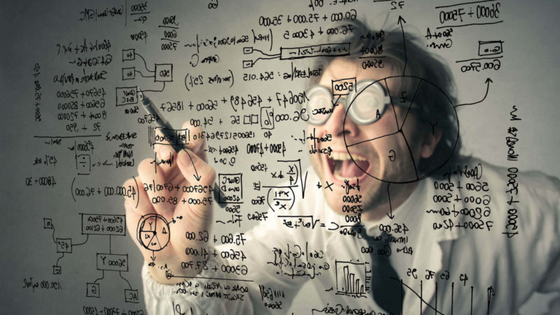 Data scientist scribbling furiously on transparent board