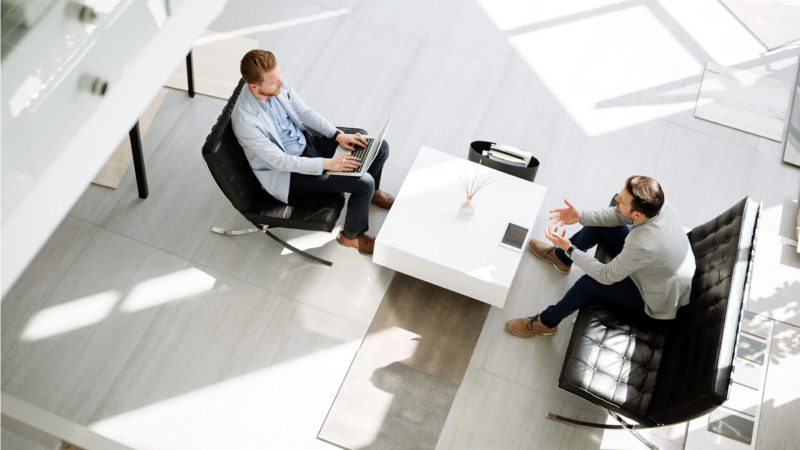 A photo of two individuals having a business meeting.