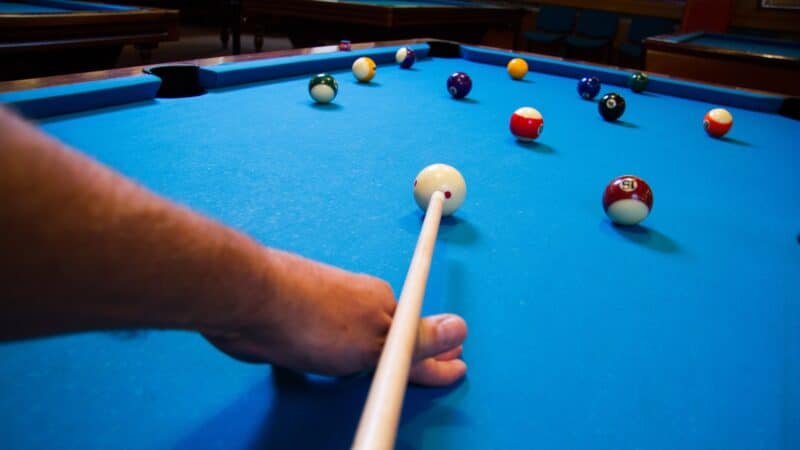 Man playing pool, taking a shot