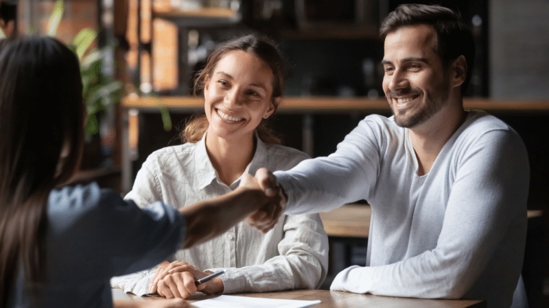 Couple shaking hands with agent