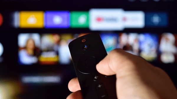 Man-holding-remote-control-with-smart-TV-on-the-background