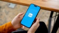 Woman-holding-smartphone-with-LinkedIn-logo-on-screen