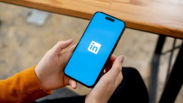 Woman-holding-smartphone-with-LinkedIn-logo-on-screen