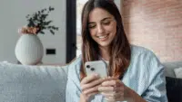 Smiling-woman-looking-at-smartphone-screen