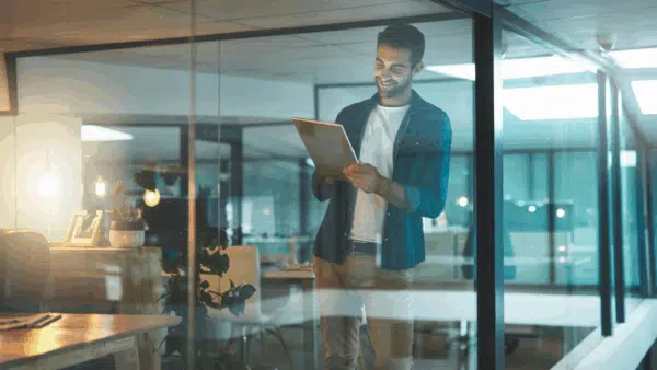 Man-happily-reading-email-on-a-tablet