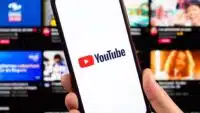 YouTube-logo-on-smartphone-with-blurred-interface-at-background