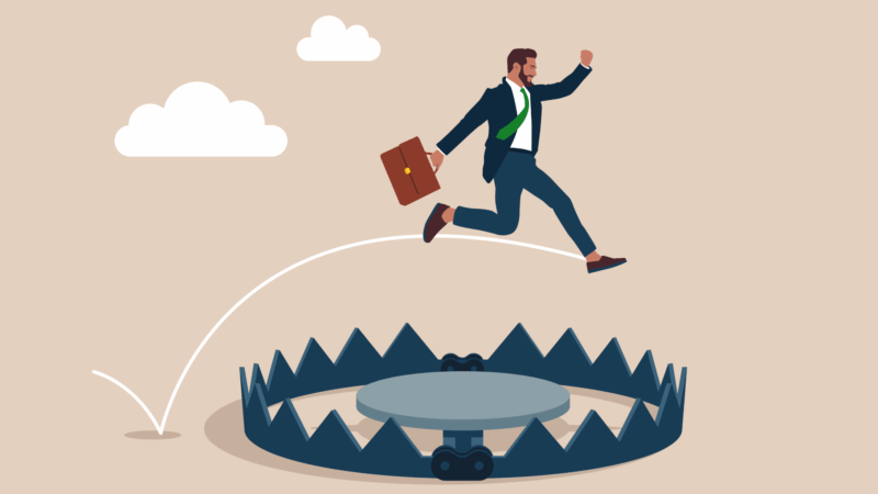 cartoon image of a business man jumping over a trap